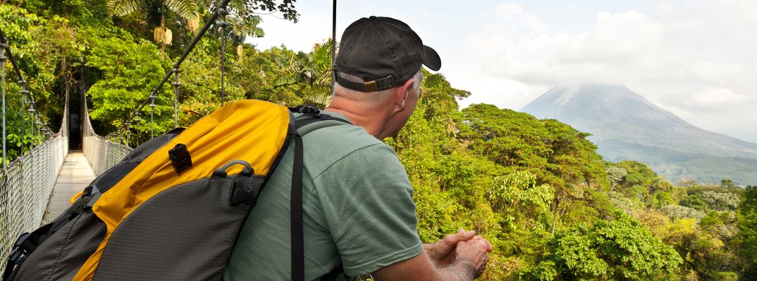 Mann mit Rucksack blickt über die bewaldete Landschaft im Nationalpark von Costa Rica
