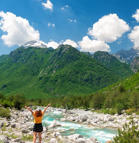 Frau blickt auf Flusslandschaft in Albanien