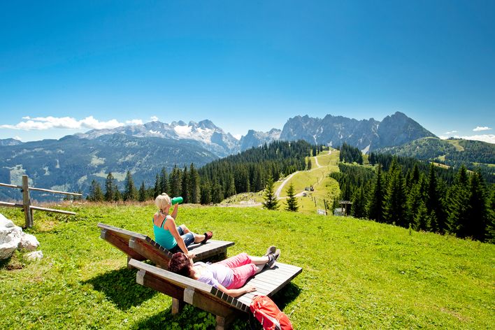 Frauen auf Bank mit Aussicht auf die Alpen