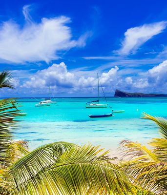 Strand von Cap Malheureux auf Mauritius mit Palmen, türkisblauem Meer und Booten