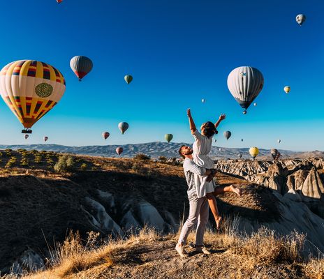 Paar unter Heißluftballons in Kappadokien