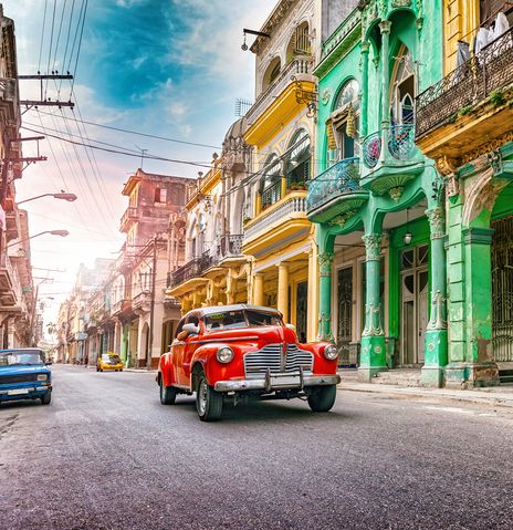 Bunte Oldtimer in den Straßen mit bunten Häuserfassaden von Havanna