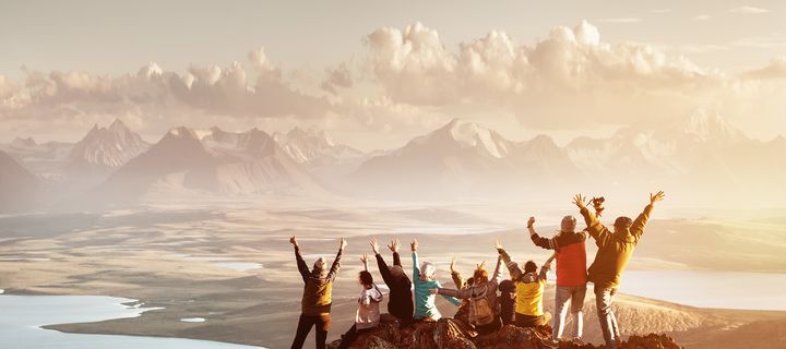 Menschen stehen auf einem Berggipfel und freuen sich