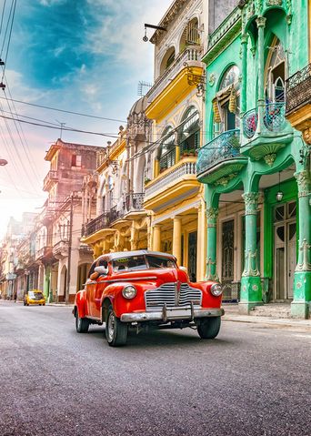Roter Oldtimer fährt durch Havanna