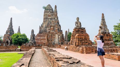 Eine Frau spaziert durch die Tempelanlage von Ayutthaya