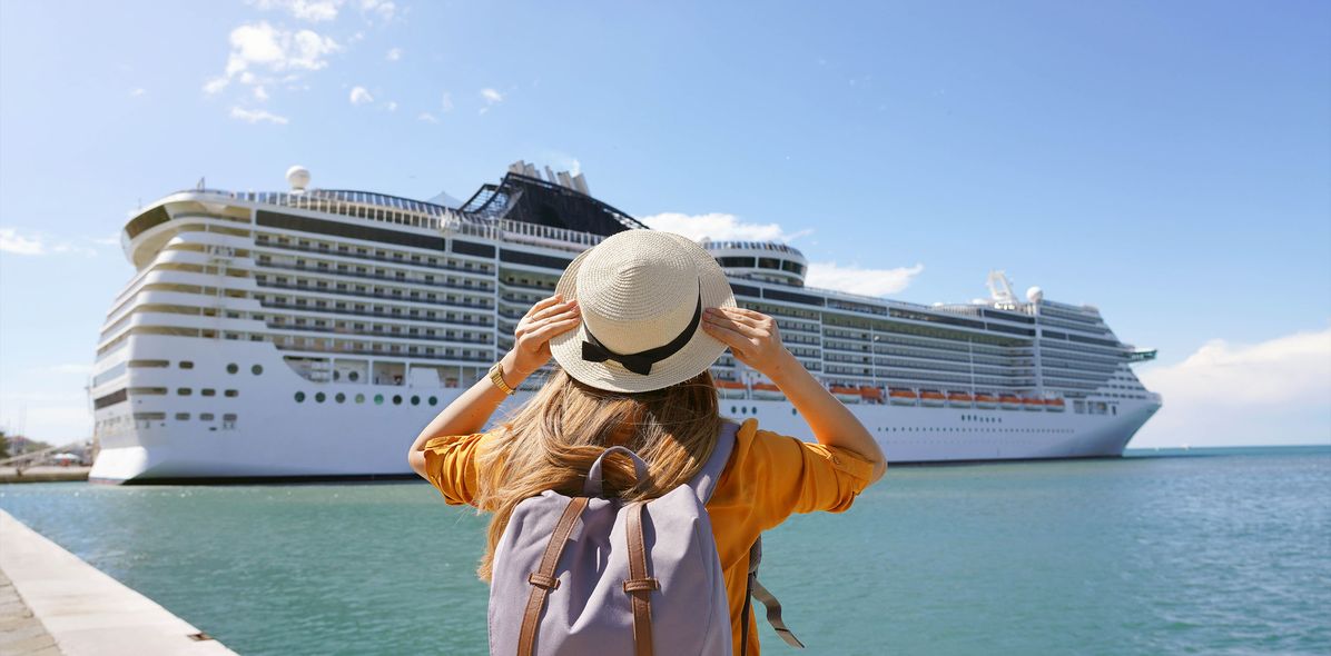 Frau vor Kreuzfahrtschiff