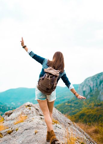 Balancierende Frau beim Wandern mit Ausblick 