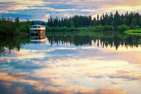 Der Fluss bei Fairbanks mit einem Boot während der Abenddämmerung in Alaska, USA