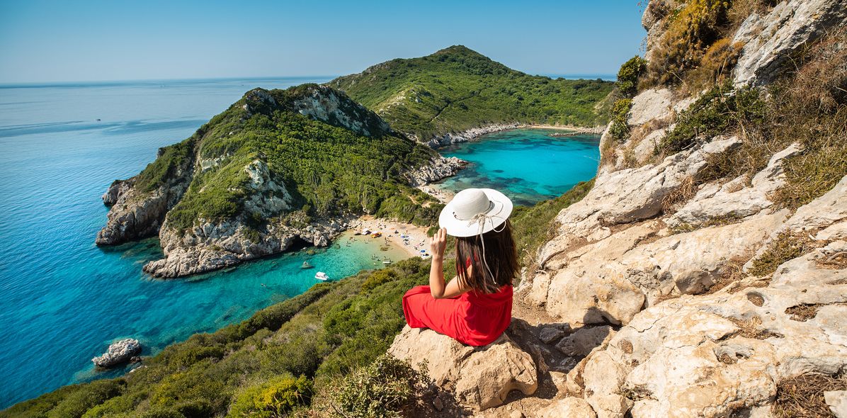 Frau auf Felsen mit Ausblick auf das Meer vor Korfu