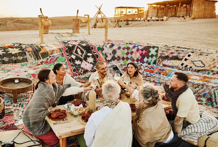 Eine Gruppe von Menschen speisen gemeinsam in einem Wüstencamp in der Wüste von Marokko