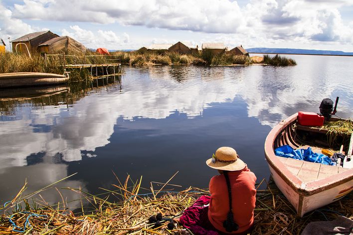 Boot auf dem Titicacasee bei Puno mit Spiegelungen im ruhigen Wasser