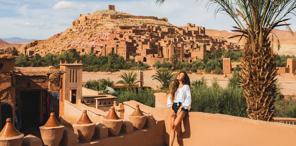 Eine Frau blickt auf die historischen Lehmbauten von Ait-Ben-Haddou