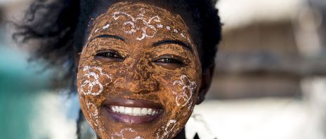 Frau mit traditioneller Gesichtsbemalung in Madagaskar