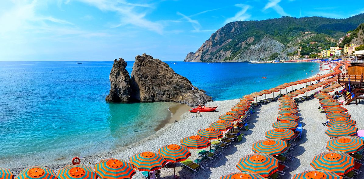 Strand in Cinque Terre mit bunten Sonnenschirmen und Küstenblick