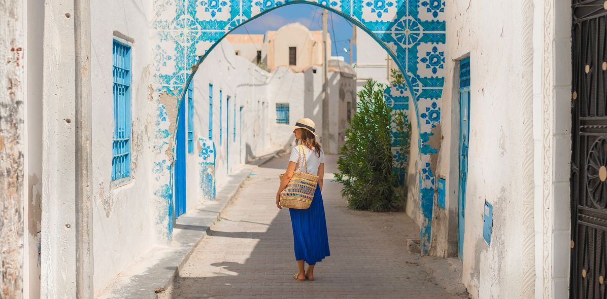 Eine Frau spaziert durch die Gassen des Houmt Souk in Djerba, Tunesien