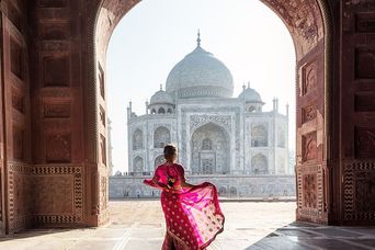 Frau vor dem Taj Mahal im roten Sari