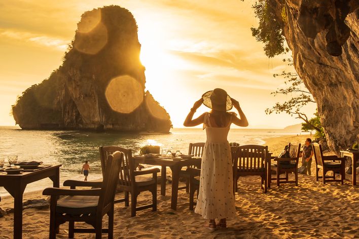 Eine Frau an den berühmten Phra Nang Höhlen im Sonnenuntergang in Thailand