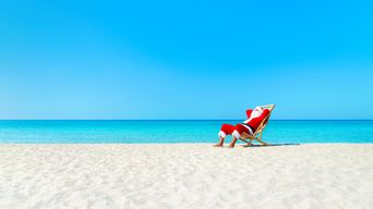 Weihnachtsmann im Liegestuhl am Strand