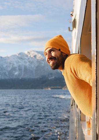 Mann blickt aus einem Kreuzfahrt-Schiff