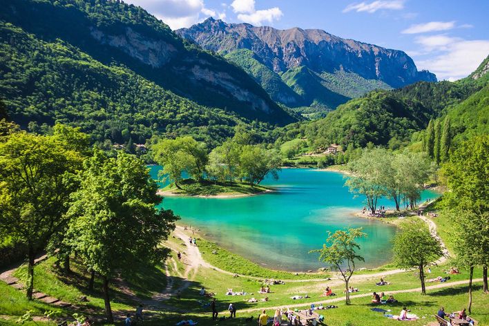 Panoramablick auf den Tennosee umrahmt von Bäumen und Bergen in Trentino in Italien