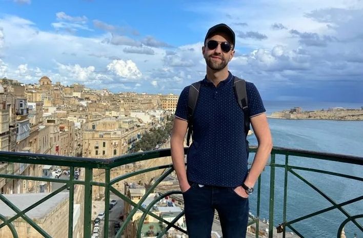 Berge & Meer-Mitarbeiter Patrick auf einem Balkon vor den Dächern von Valletta in Malta