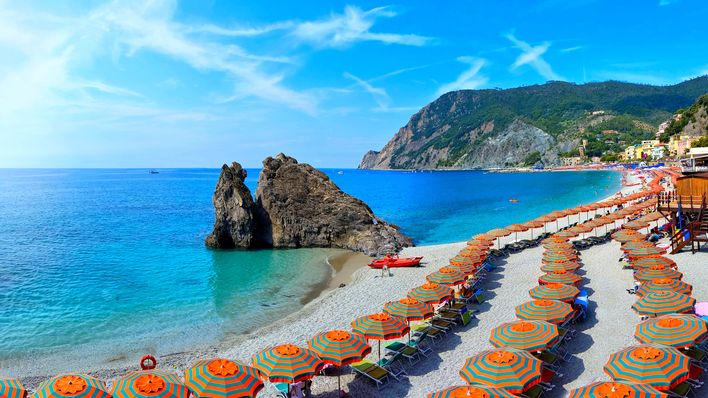 Strand in Cinque Terre mit bunten Sonnenschirmen und Küstenblick