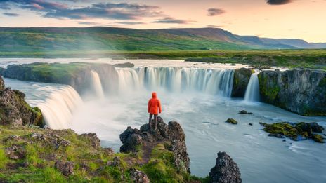 Mann am Wasserfall auf Island