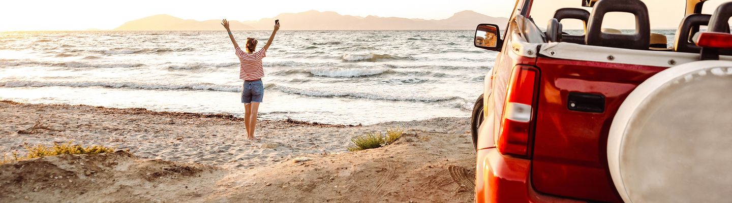 Frau mit Auto am Strand