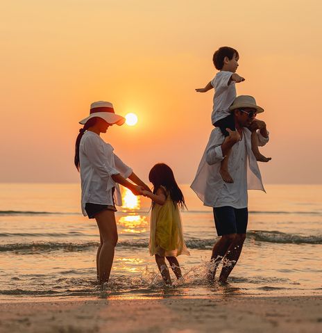 Familie am Strand bei Sonnenuntergang