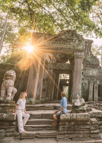 Paar sitzt auf Treppen in Angkor Wat und bestaunt die Anlage