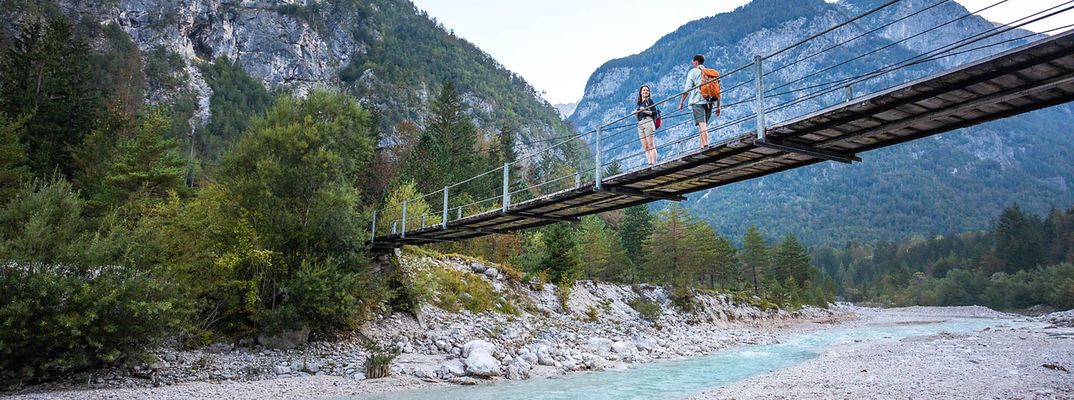 Soca-Fluss in Slowenien mit Hängebrücke, Bergen und kristallklarem Wasser
