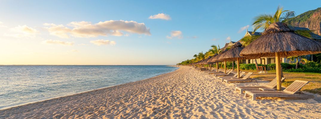 Strand mit Liegen und Sonnenschirmen auf Mauritius