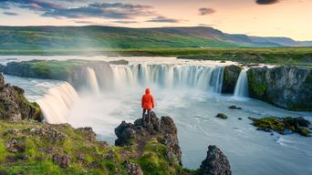 Mann vor einem Wasserfall auf Island