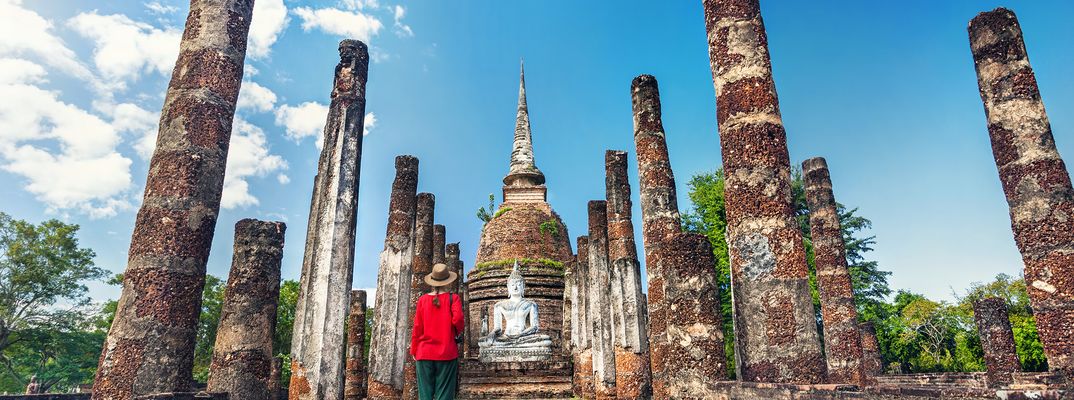 Eine Frau in der Tempelanlage von Sukothai in Thailand