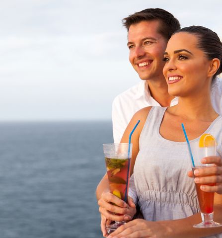Paar mit Cocktails auf Kreuzfahrtschiff