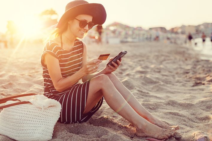 Frau am Strand mit Handy