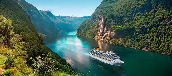 Ein Schiff der Reederei Costa Kreuzfahrten, welches durch einen Fjord fährt