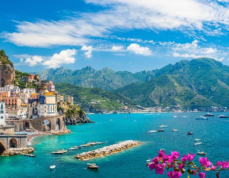 Panoramablick auf ein buntes Bergdorf am Meer mit Felsen, Bergen und Blumen an der Amalfiküste in Italien