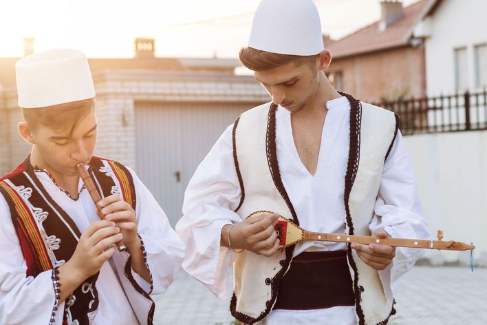 Albaner in traditioneller Kleidung machen Musik