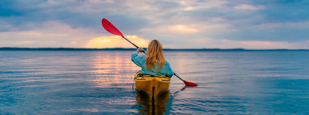 Frau beim Kanufahren in Finnland