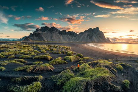 Mensch am schwarzen Strand Stokksnes in Island