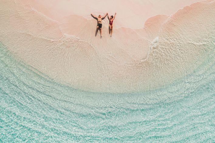 Pärchen liegt im Sand am Meer