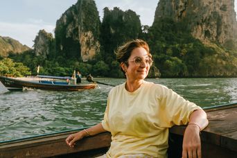 Frau genießt eine Bootsfahrt vor den Kalksteinfelsen der thailändischen Inselwelt bei Krabi