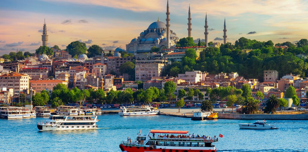 Blick auf die Skyline Istanbuls vom Wasser aus mit Moscheen, Booten und Hügeln
