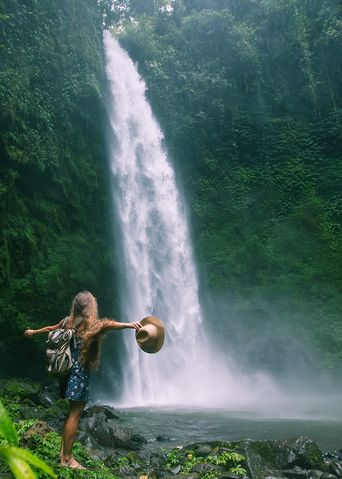 Frau am Wasserfall auf Bali