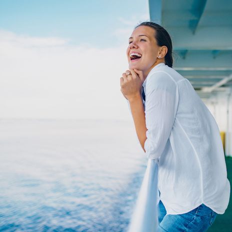 Fröhliche Frau auf Kreuzfahrtschiff