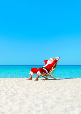 Weihnachtsmann im Liegestuhl am Strand