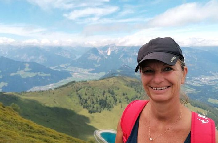 Berge & Meer-Mitarbeiterin Gerlind vor grüner Landschaft im Alpbachtal in Österreich