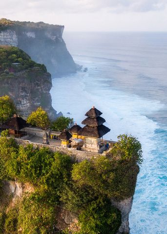 Luftaufnahme des Uluwatu-Tempels auf Bali auf einer Klippe über dem Meer bei Sonnenaufgang