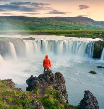 Mann an einem Wasserfall auf Island